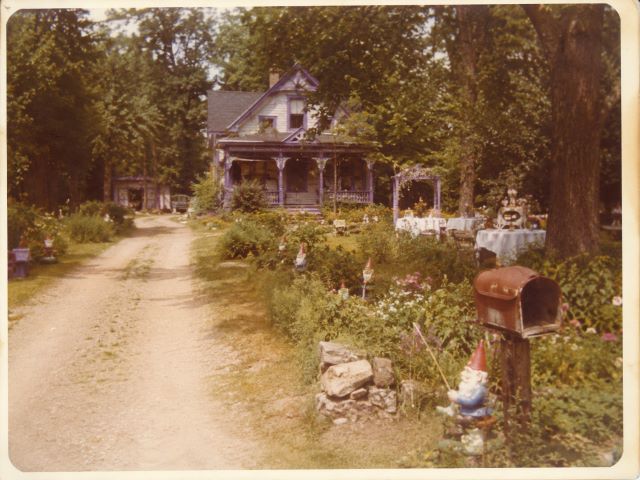 Adel's house at the end of the dirt road, with purple trim and garden gnomes
