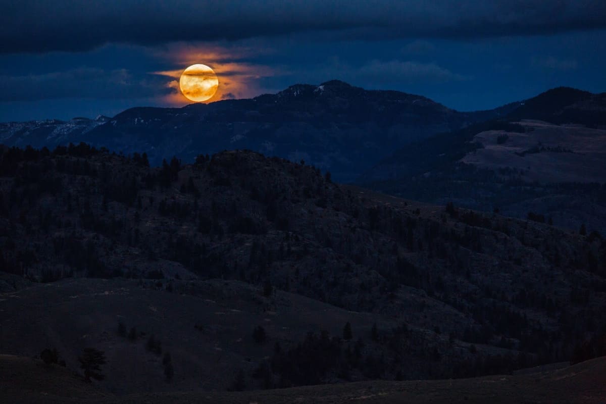 Full moon over the mountains at night